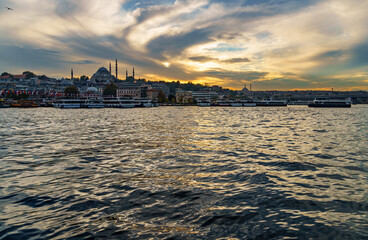 Fototapeta premium view from a pleasure boat on the Bosphorus and the cityscape of Istanbul, Turkey, the architecture of the city at sunset, a popular tourist destination.