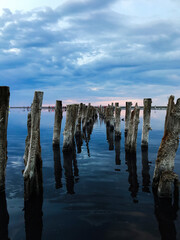 Fototapeta premium Old wooden pier extending into tranquil reflective water