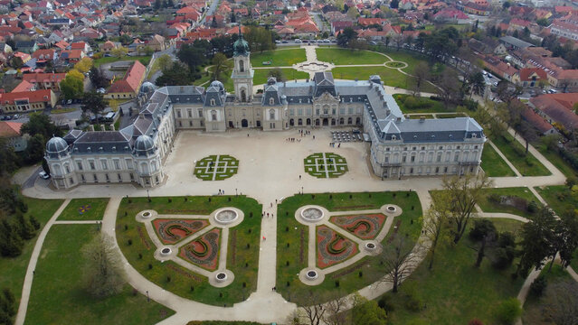 Aerial view of the grandeur of Festetics Palace in Keszthely, Hungary, surrounded by meticulously designed gardens and pathways. The baroque architecture, with its ornate facade and elegant symmetry.