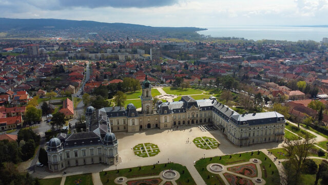 Aerial view of the grandeur of Festetics Palace in Keszthely, Hungary, surrounded by meticulously designed gardens and pathways. The baroque architecture, with its ornate facade and elegant symmetry.