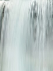 Serene Waterfall: A Softly Blurred Cascade of White Water Against a Natural Background - Ideal for Relaxation and Nature Themes