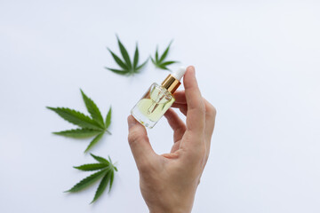 Fototapeta premium Womans hand holding small bottle of cannabis oil. Cannabis oil for beauty treatments.