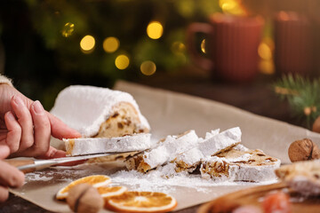 Slices of Christmas stollen on wooden background. Traditional Christmas festive pastry dessert. Stollen is treat for Christmas