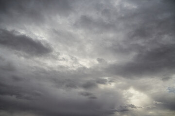 Fototapeta premium Altostratus clouds - a dense veil of grayish hue, with white or gray tufts spread across the sky, indicating light rain.