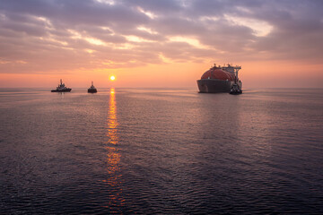 Lng tanker arriving at harbor at susnet. Oil and gas industry, liquefied natural gas tanker, ship