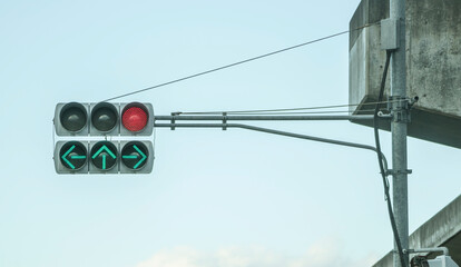 traffic light in japan with red light and arrows with green light indicating to go straight ahead, turn right and turn left. japanese traffic light