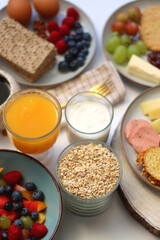 Assortment of various breakfast foods and drinks on the white table. Selective focus.
