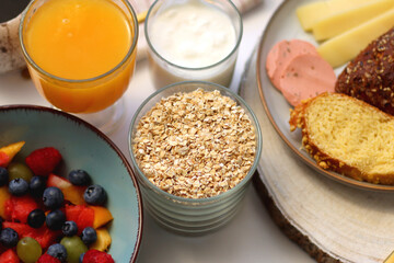 Assortment of various breakfast foods and drinks on the white table. Selective focus.