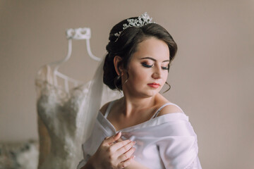 A woman in a white dress is wearing a tiara and is posing for a picture. The image has a soft and...