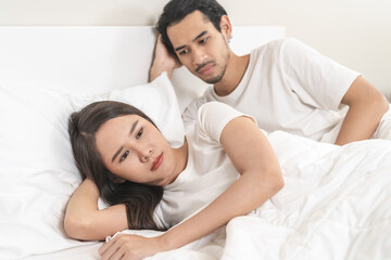 Angry, depressed, frustrated asian couple quarrel, fighting on bed in conflict, divorce or relationship problem, stress from marriage, fight and argument, unhappy married couple and sexual impotent.