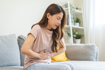 Flatulence asian young woman intolerance hand in stomach ache, suffer from food poisoning,...