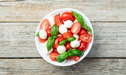 Basil leaves , cherry tomatoes and mozzarella cheese . In bowl food photography