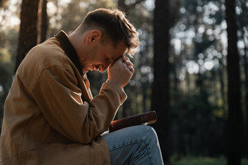 Christian read and pray with holy bible in forest with Holy light shining. Pray to God to confess...