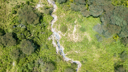 Aerial view of a geological fault forming an arid rocly zigzag scar, surrounded by lush green nature highlighting the natural formations and ecosystems, perfect for geology and environmental concepts