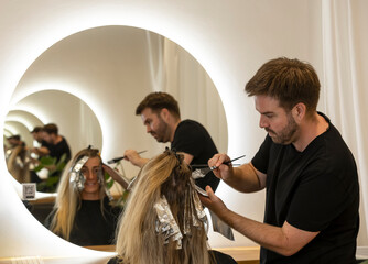 Junge Frau erh&auml;lt beim Friseur Str&auml;hnchen