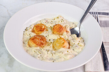 clam chowder top  with herbs and scallops