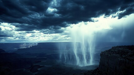 Fototapeta premium Dramatic monsoon rain pours into the Grand Canyon under a dark, brooding sky.