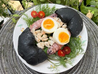 Crab, mantis shrimp and soft boiled with egg black charcoal bagel