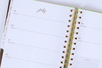 Planner opened to month of July shows empty weekly sections, providing space for scheduling events, jotting down notes, organizing tasks.