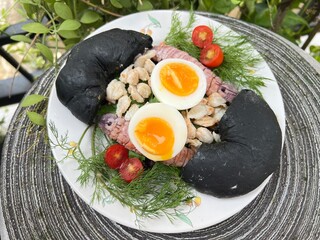 Crab, mantis shrimp and soft boiled with egg black charcoal bagel