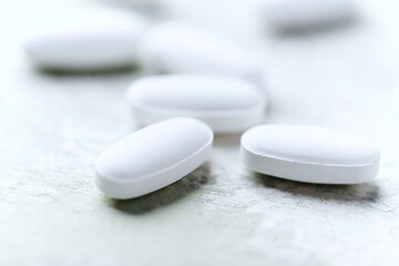 White tablets on wooden background. Soft focus. Close up. Copy space