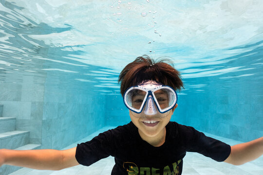 Boy swimming underwater in a pool 