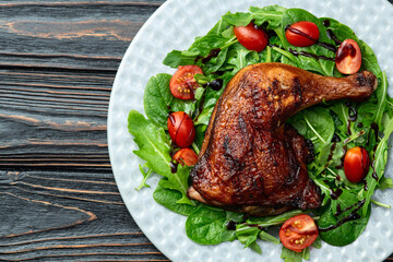 Grilled chicken legs with tomatoes and salad . Top view