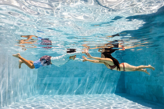 Mother and Son playing underwater in a pool 