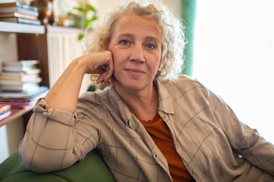 Portrait of a confident mature woman sitting at home looking thoughtful