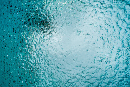 View above underwater in a pool while it is raining 