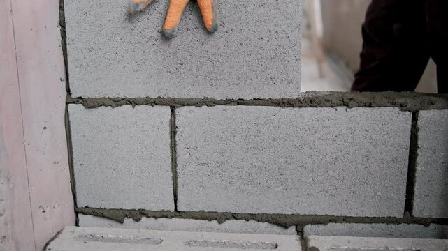 Construction worker laying concrete blocks to create a sturdy wall for residential building projects