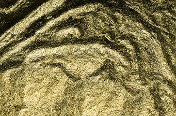 Heavily wrinkled texture of gold-colored foil