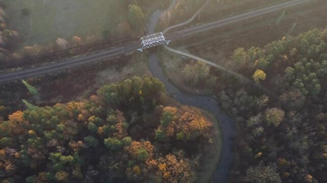 Most kolejowy nad rzeką o mglistym poranku