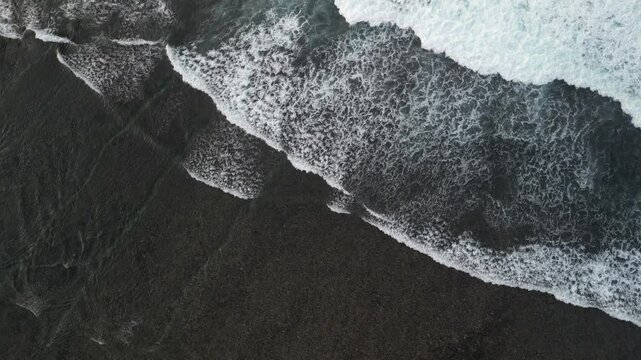 4k video footage - Aerial view of Watu Karung Beach, Pacitan, East Java, Indonesia with crashing waves during cloudy day. Cape with cliffs by the sea and green plants around at tropical island
