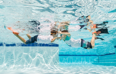 Boys playing underwater in a pool 