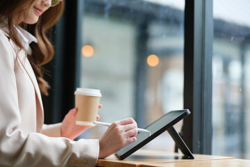 Close-up of a businesswoman using a tablet and stylus for work
