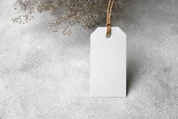 Blank price tag card mockup with dry gypsophila flowers decor, white label mock up with copy space