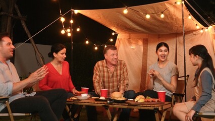 Family together celebrate anniversary in garden. Senior give gift to granddaughter. Outdoor camping activity to relax with relatives, spend time with multigeneration cross generation gap. Divergence.