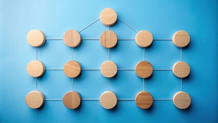 Obraz premium Wooden circles connected by string on a blue background creating an abstract pattern of connection and organization.
