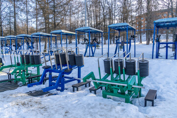 The gym  equipment and machines for physical development training in the snow-covered park at Petrozavodsk, northern Russia.
