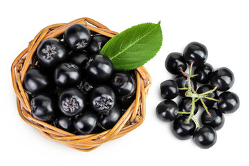 Chokeberry with leaf in a wicker basket isolated on white background. Black aronia. Top view. Flat lay