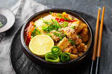 A bowl of glass or cellophane noodles with Asian caramelized chicken breast on a table