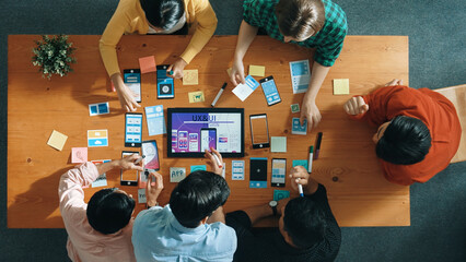 Top down view of business team writing idea on sticky note while planing for Ux Ui design for...