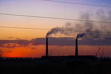 View of the plant's chimneys against the backdrop of sunset.