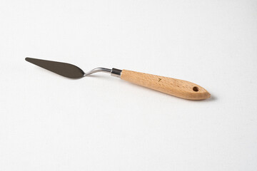 Palette knife on a white canvas. A clean new palette knife on canvas. A drawing tool.