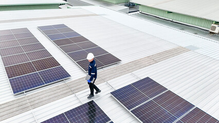 Aerial view of a rooftop with solar panels, showing a technician in safety gear performing maintenance. The scene highlights renewable energy, solar technology, and sustainable infrastructure.