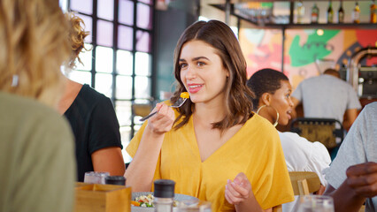Group Of Young Friends Meeting For Drinks And Food In Bar Or Restaurant