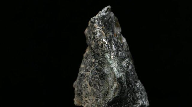 Actinolite [calcium silicate hydroxide] specimen rotating slowly against a black background.