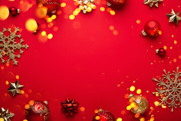 Merry Christmas and Happy Holidays greeting card, frame, banner. New Year. Noel. Red and golden Christmas decoration on red background top view. Winter xmas holiday festive theme.
