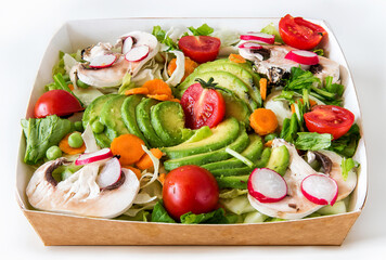 take-away package of a salad with raw vegetables with avocado, tomatoes , mushrooms , peas , carrots , radish, lettuce and onion.